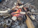 Stockbrot wird über einem offenen Lagerfeuer gebacken.